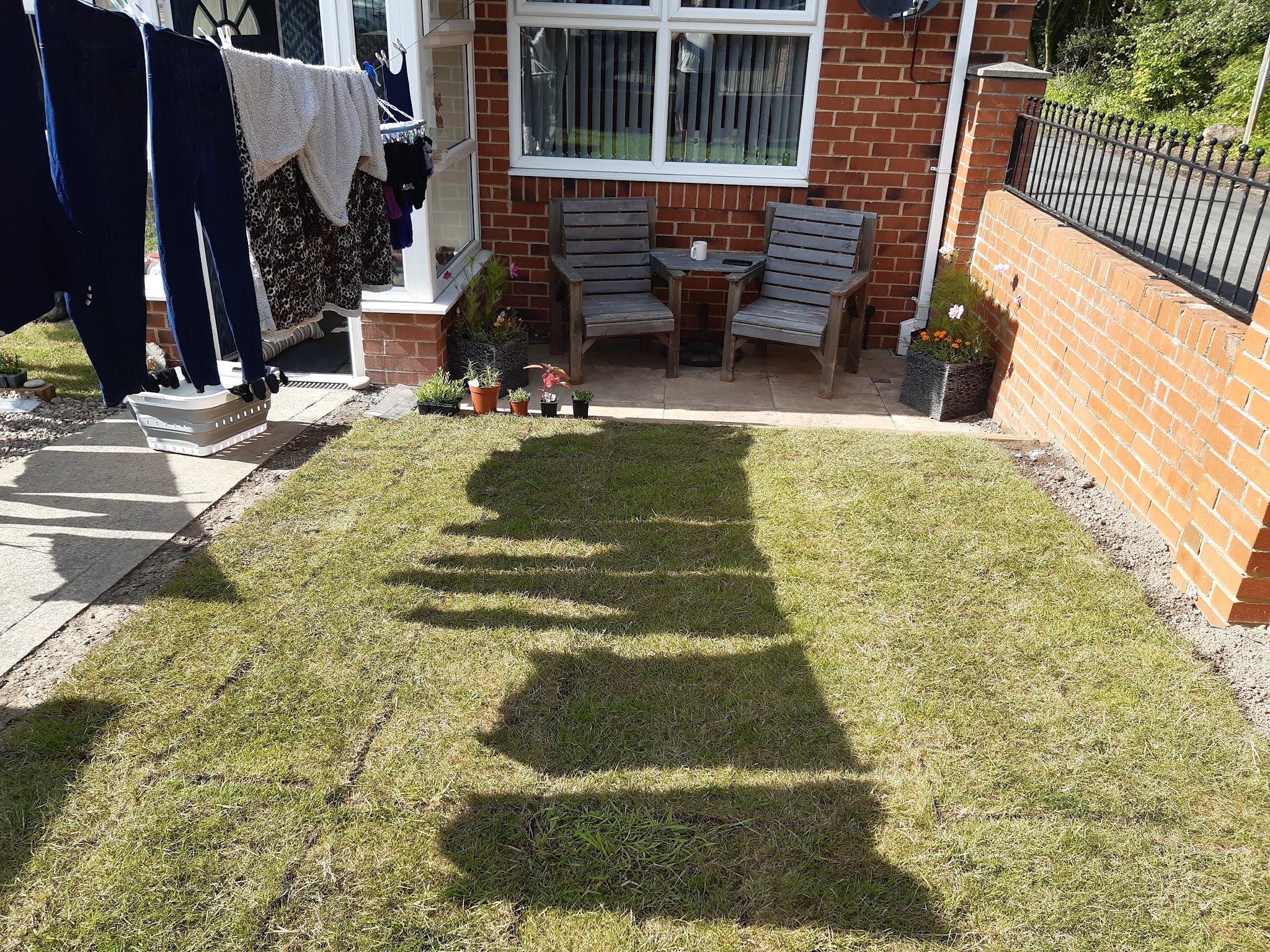 A newly turfed lawn with a patio seating area