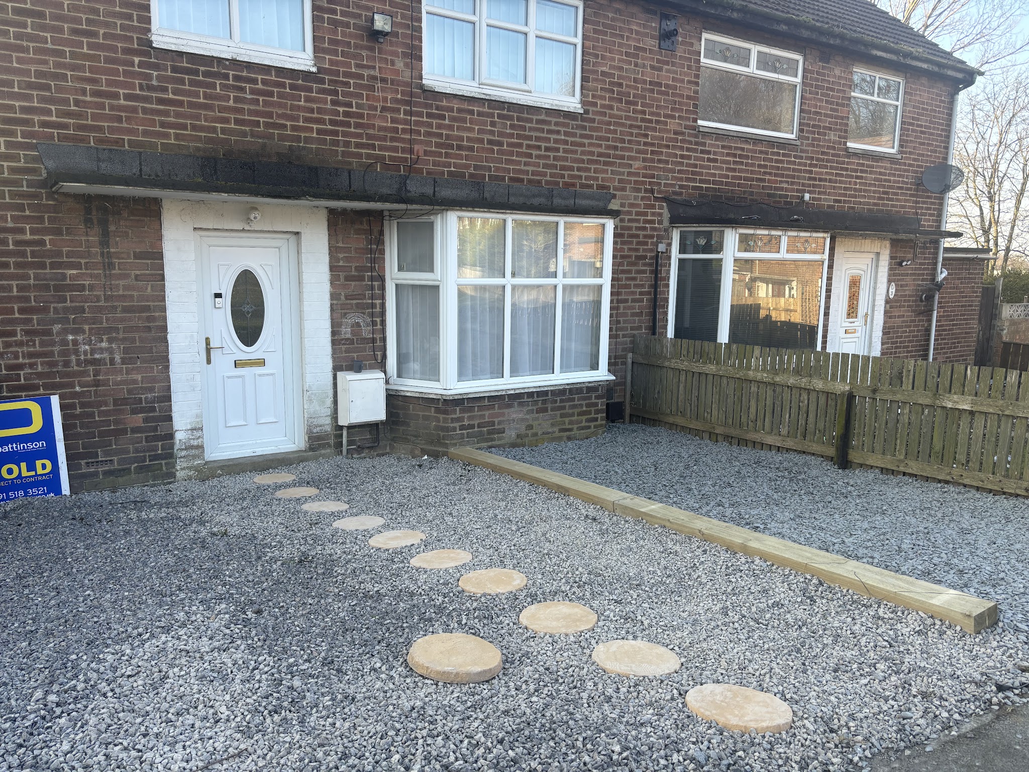 A tidy gravel front garden with stepping stones and a timber edge