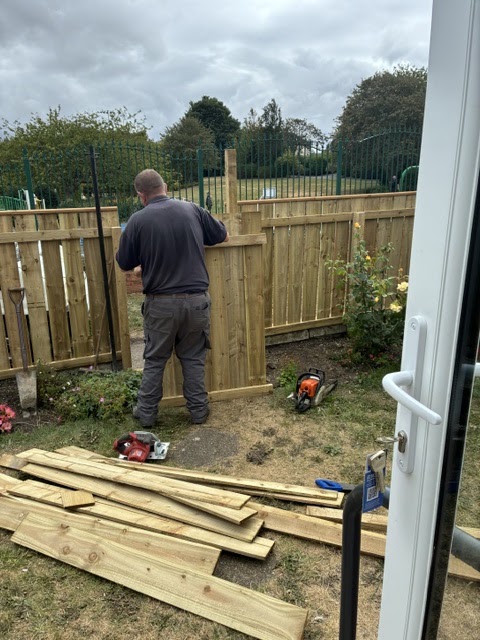 Stuart fitting a new fence panel in a back garden